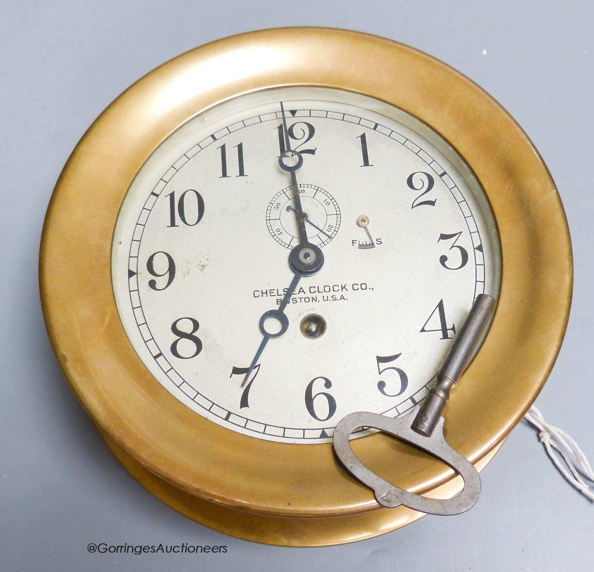 An early 20th century Chelsea Clock Company bronze cased ship's bulkhead timepiece, with key, 19cm diameter